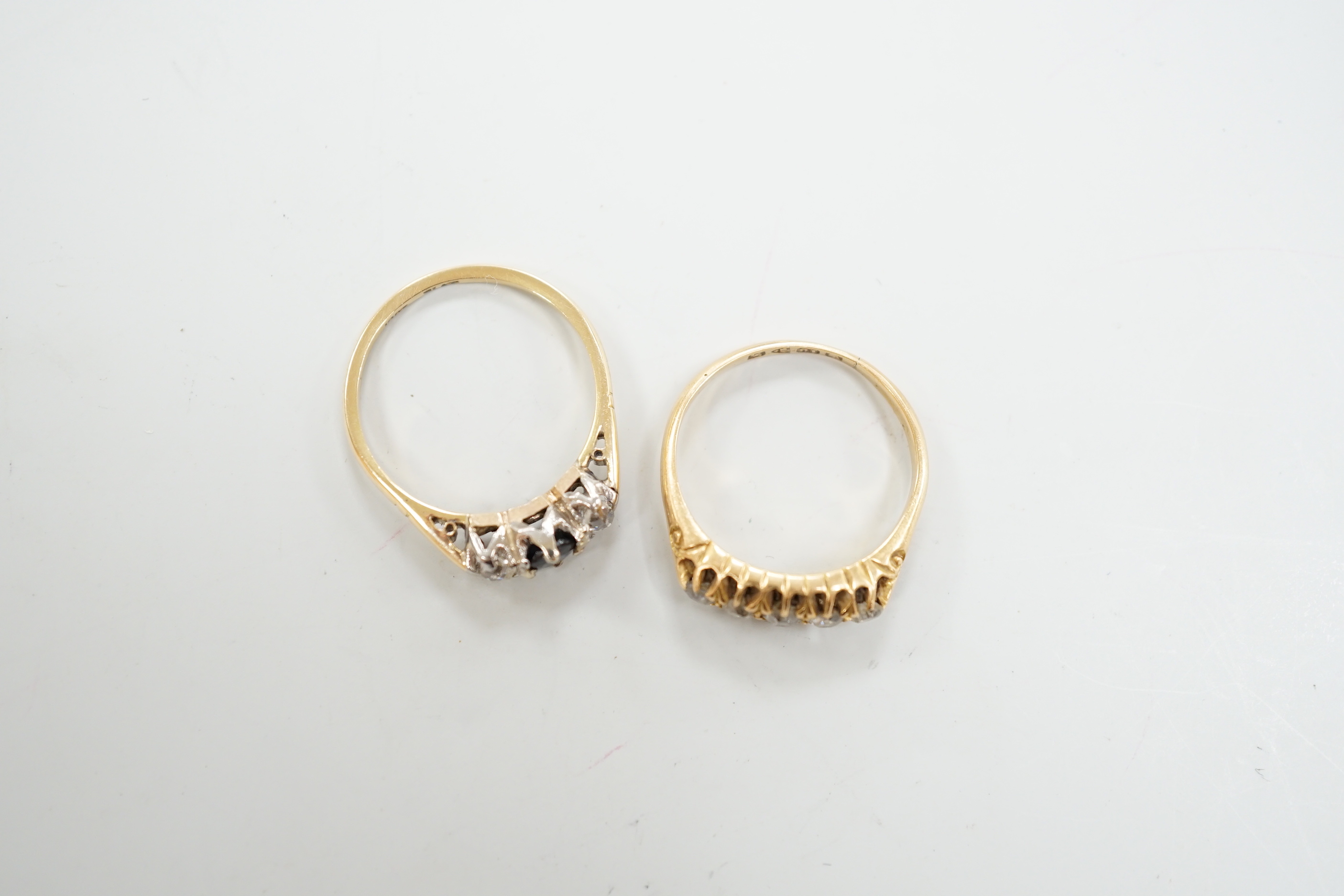 A George V 18ct gold and graduated five stone diamond chip set half hoop ring, size O and a similar 18ct, sapphire and diamond set three stone ring, gross weight 6 grams.